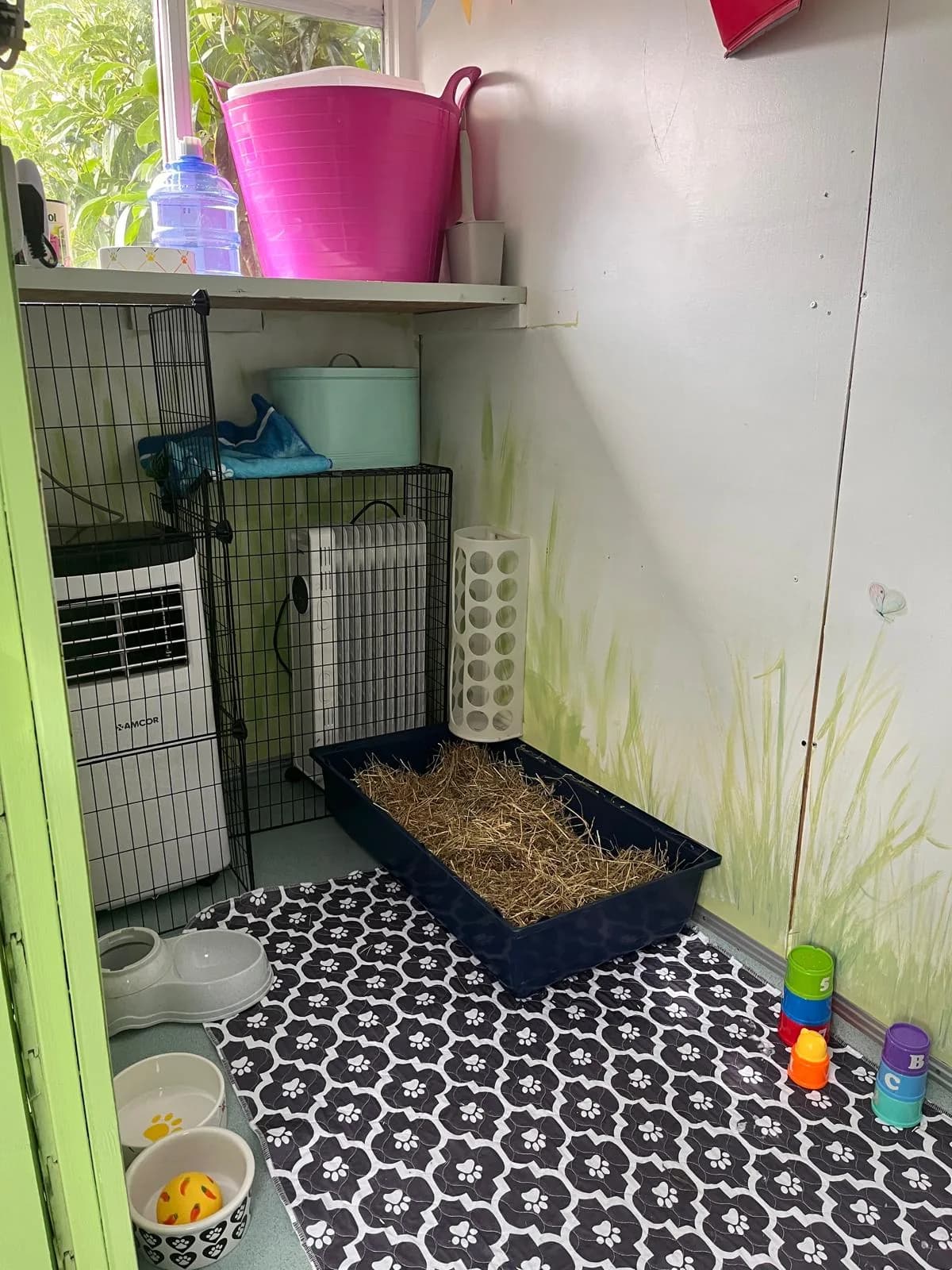 Air conditioning, a guarded radiator, hay tray and food bowls inside Apple Tree Lodge