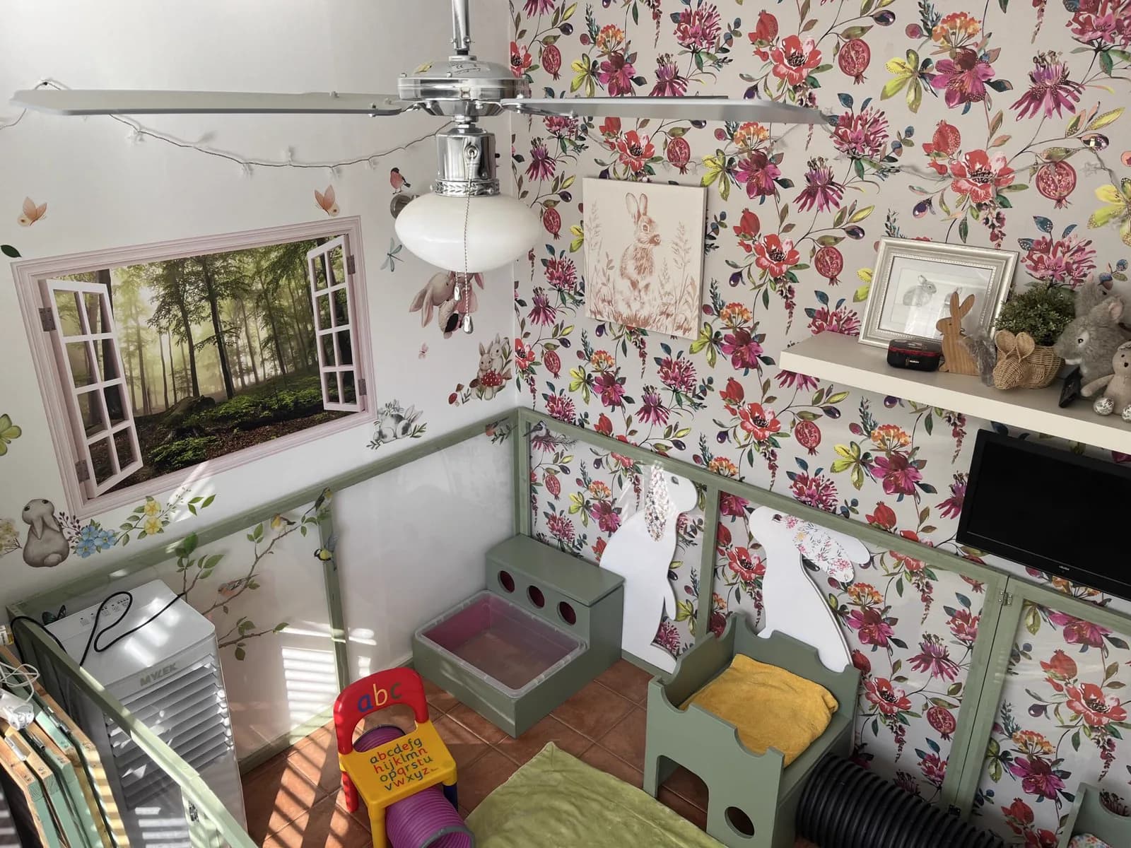 Ceiling fan, air cooler and painted woodland window in the Indoor Bunny Room